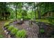 An outdoor stone patio features a table and seating, perfect for relaxing or entertaining in a lush, green setting at 4777 Helena Moriah Rd, Rougemont, NC 27572