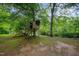A charming wooden treehouse, set amongst mature trees, is a backyard addition that invites adventure and fun at 4777 Helena Moriah Rd, Rougemont, NC 27572