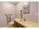 Cozy bathroom featuring a vanity with a sink, toilet, mirror, and decorative wallpaper border at 506 E E St, Butner, NC 27509