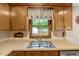 Kitchen sink, wood cabinets, and a window that offers a view of the backyard shed at 506 E E St, Butner, NC 27509