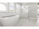 Bright bathroom featuring marble floors, walk-in shower, and a luxurious soaking tub at 5100 Schellinger, Raleigh, NC 27612