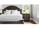 Close up of bedroom with a wooden bedframe, white pillows, and a wooden nightstand at 5100 Schellinger, Raleigh, NC 27612