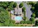Aerial view of a community pool with plenty of lounge chairs, mature trees, and an adjacent parking lot at 5100 Schellinger, Raleigh, NC 27612