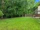 Expansive backyard featuring a lush green lawn, mature trees, and a wooded area at 552 Stobhill Ln, Holly Springs, NC 27540