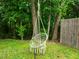 A woven hammock chair hangs from a mature tree, creating a peaceful backyard retreat at 552 Stobhill Ln, Holly Springs, NC 27540