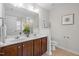Well-lit bathroom with double sinks, dark wood vanity, and tiled floors at 552 Stobhill Ln, Holly Springs, NC 27540