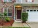 Close-up of a home's front entrance with stone veneer, a dark front door and neat landscaping at 552 Stobhill Ln, Holly Springs, NC 27540