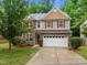 Charming two-story home with a stone accent, a two-car garage, and a well-manicured lawn at 552 Stobhill Ln, Holly Springs, NC 27540