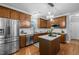 Bright kitchen with stainless appliances, subway tile backsplash, wood cabinets, and a center island at 552 Stobhill Ln, Holly Springs, NC 27540