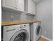 Laundry room with a washer, dryer, and overhead cabinets at 552 Stobhill Ln, Holly Springs, NC 27540