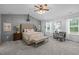 Spacious primary bedroom featuring a vaulted ceiling, panel accent wall, bench, and natural light at 552 Stobhill Ln, Holly Springs, NC 27540