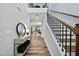 Bright hallway with hardwood floors leading to an open living space and staircase with modern railings at 6036 Balance Ct, Raleigh, NC 27616