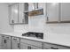 Modern kitchen featuring gray cabinets, stainless steel range hood, subway tile backsplash, and gas cooktop at 6036 Balance Ct, Raleigh, NC 27616