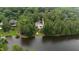 Stunning aerial view of a home by the lake surrounded by lush greenery and trees at 636 Pendleton Lake Rd, Raleigh, NC 27614