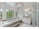 Spa bathroom featuring soaking tub, vanity, and bright natural light from windows at 636 Pendleton Lake Rd, Raleigh, NC 27614