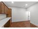 Bonus room with white countertop, cabinets, and wood-look flooring with door on right side at 636 Pendleton Lake Rd, Raleigh, NC 27614