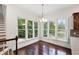 Breakfast area with hardwood floors, charming chandelier and scenic views from surrounding windows at 636 Pendleton Lake Rd, Raleigh, NC 27614