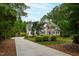 Beautiful two-story home with stone accents, a long driveway, and a lush green lawn at 636 Pendleton Lake Rd, Raleigh, NC 27614