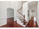 Grand foyer with hardwood floors, curved staircase, and wainscoting at 636 Pendleton Lake Rd, Raleigh, NC 27614