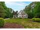 Stately two-story home with stone accents, black shutters, and a lush, landscaped front yard at 636 Pendleton Lake Rd, Raleigh, NC 27614