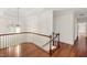 Upstairs hallway with hardwood floors and natural light streaming through a window at 636 Pendleton Lake Rd, Raleigh, NC 27614