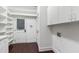 Well-lit laundry room with white cabinetry, hardwood floors, and outdoor access at 636 Pendleton Lake Rd, Raleigh, NC 27614
