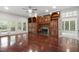 Spacious living room features a fireplace, built-in shelves, hardwood floors, and access to the deck and sunroom at 636 Pendleton Lake Rd, Raleigh, NC 27614