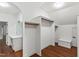 Spacious walk-in closet with wooden floor, makeup table and storage bench with white walls and trim at 636 Pendleton Lake Rd, Raleigh, NC 27614