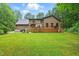 Expansive backyard with brick house, wooden deck, and lush green lawn surrounded by mature trees at 6617 Whitted Rd, Fuquay Varina, NC 27526