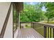 Relaxing outdoor balcony with wood decking, brown railings and trim, offering views of lush green trees and the neighborhood at 6617 Whitted Rd, Fuquay Varina, NC 27526