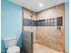 Contemporary bathroom featuring a tiled shower with a glass panel and blue accent wall at 6617 Whitted Rd, Fuquay Varina, NC 27526