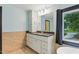 Elegant bathroom featuring a vanity with white cabinets, granite countertop, and a window with tile flooring at 6617 Whitted Rd, Fuquay Varina, NC 27526