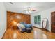 Charming bedroom with a wood accent wall, hardwood floors, and a ceiling fan, creating a warm ambiance at 6617 Whitted Rd, Fuquay Varina, NC 27526
