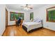 Comfortable bedroom featuring a bay window, hardwood floors, and a ceiling fan, offering a relaxing retreat at 6617 Whitted Rd, Fuquay Varina, NC 27526