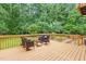 Wooden deck with outdoor seating offering a view of the expansive green yard and mature trees at 6617 Whitted Rd, Fuquay Varina, NC 27526