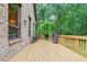 Large wooden deck with outdoor seating area, connected to a brick house surrounded by lush greenery at 6617 Whitted Rd, Fuquay Varina, NC 27526