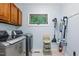 Well-lit laundry room with modern washer and dryer, and storage solutions at 6617 Whitted Rd, Fuquay Varina, NC 27526