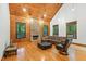 Spacious living room with wood paneling, vaulted ceiling, brick fireplace, and hardwood floors at 6617 Whitted Rd, Fuquay Varina, NC 27526