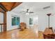 Bright living room with hardwood floors, white walls, ceiling fan, and charming wicker chair and ottoman at 6617 Whitted Rd, Fuquay Varina, NC 27526