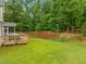 Expansive backyard with a well-maintained lawn and a view of the deck, screened porch, and surrounding trees at 6949 Rex Rd, Holly Springs, NC 27540