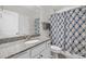 Bathroom with granite countertops, single sink vanity, framed mirror, and a shower with a patterned curtain at 6949 Rex Rd, Holly Springs, NC 27540