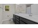 Full bathroom featuring a dual sink vanity, modern fixtures, and a window at 6949 Rex Rd, Holly Springs, NC 27540