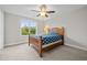 Bright bedroom featuring a ceiling fan, cozy bed, and a window with a view of the trees at 6949 Rex Rd, Holly Springs, NC 27540