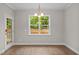 Well-lit dining room with modern chandelier and a large window offering a view of the outdoors at 6949 Rex Rd, Holly Springs, NC 27540