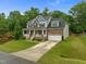 Charming two-story home with a welcoming front porch, manicured lawn, and attached two-car garage in a lovely community at 6949 Rex Rd, Holly Springs, NC 27540