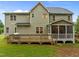 Rear exterior view of a two-story house, showcasing the deck, screened porch, and well-kept backyard at 6949 Rex Rd, Holly Springs, NC 27540