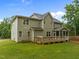 Rear exterior of a two-story house with a wooden deck, screened porch, and lush backyard at 6949 Rex Rd, Holly Springs, NC 27540