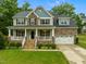 Charming two-story home with a welcoming front porch, manicured lawn, and attached two-car garage in a lovely community at 6949 Rex Rd, Holly Springs, NC 27540