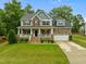 Charming two-story home with a welcoming front porch, manicured lawn, and attached two-car garage in a lovely community at 6949 Rex Rd, Holly Springs, NC 27540