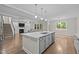 Bright, open kitchen with island, stainless steel appliances, and adjacent living space at 6949 Rex Rd, Holly Springs, NC 27540